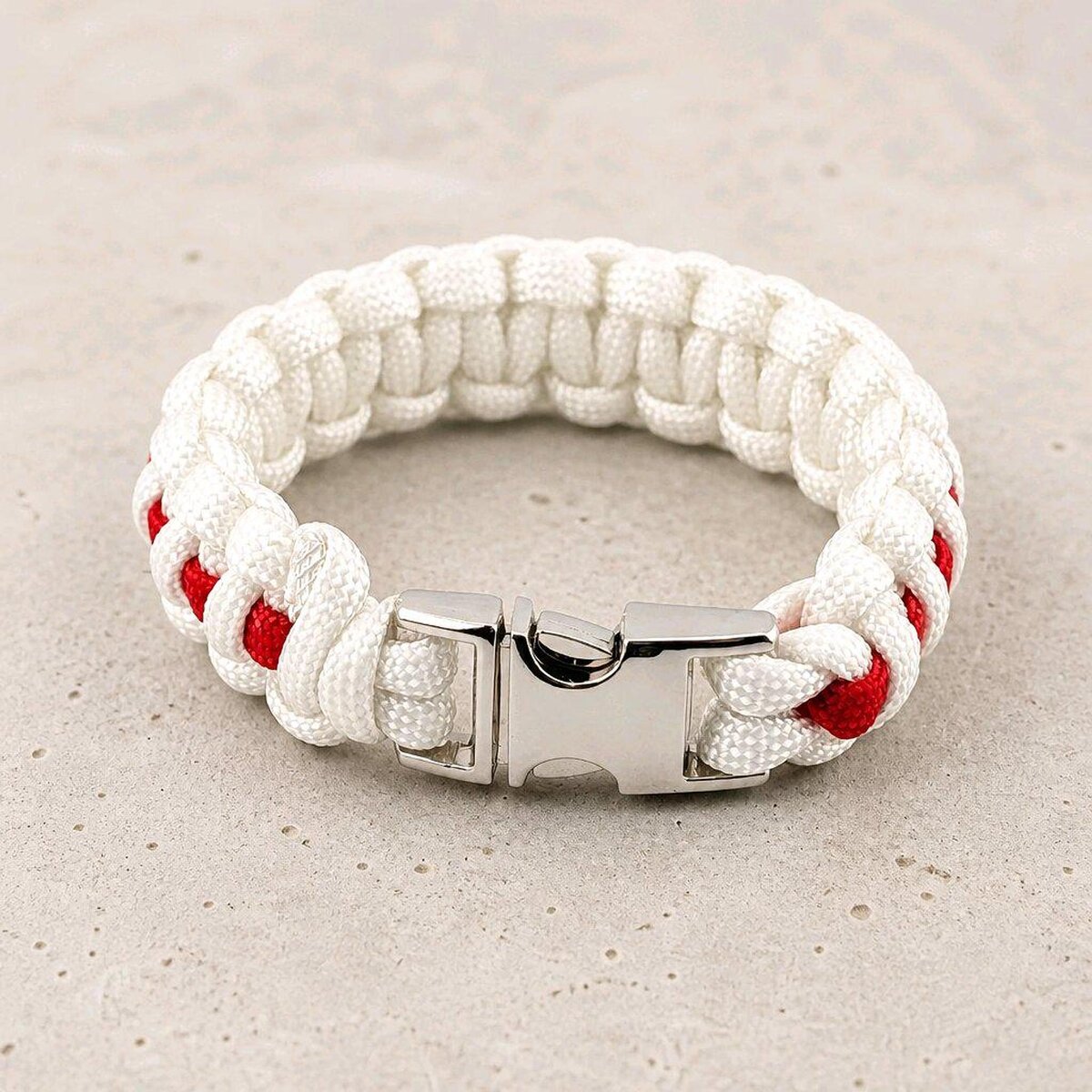 A white and red braided paracord bracelet fastened with a polished silver side-release buckle.